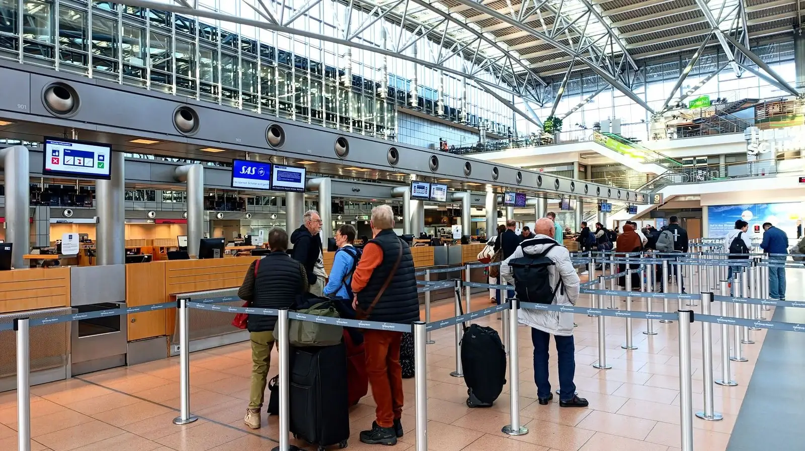Travellers queueing at airport check-in with a Sri Lanka ETA visa approval notice