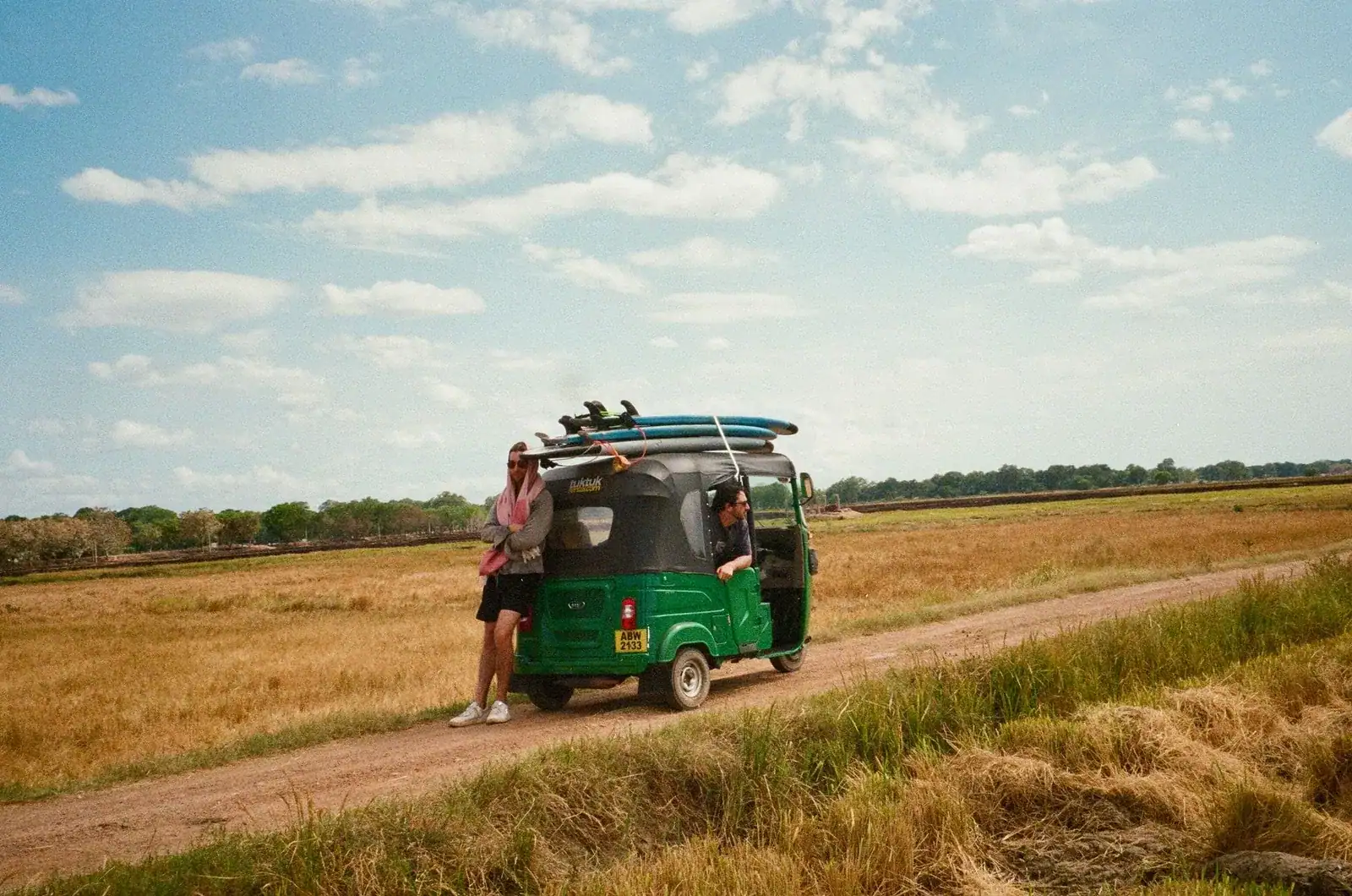 Travellers with a tuk-tuk on a rural road in Sri Lanka, one of the transport options in a package