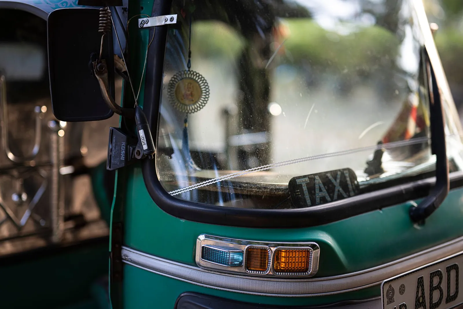 Sri Lanka tuk tuk: a green three-wheeler taxi close up on a Colombo street