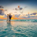 Sri Lanka honeymoon: a couple at the water's edge on a tropical beach at sunset