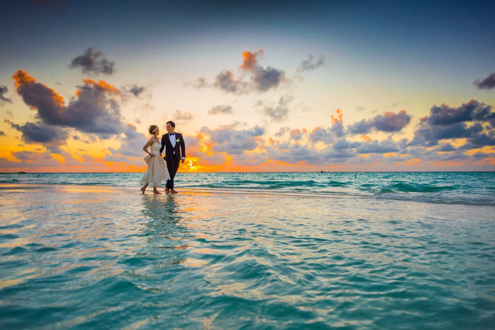Sri Lanka honeymoon: a couple at the water's edge on a tropical beach at sunset