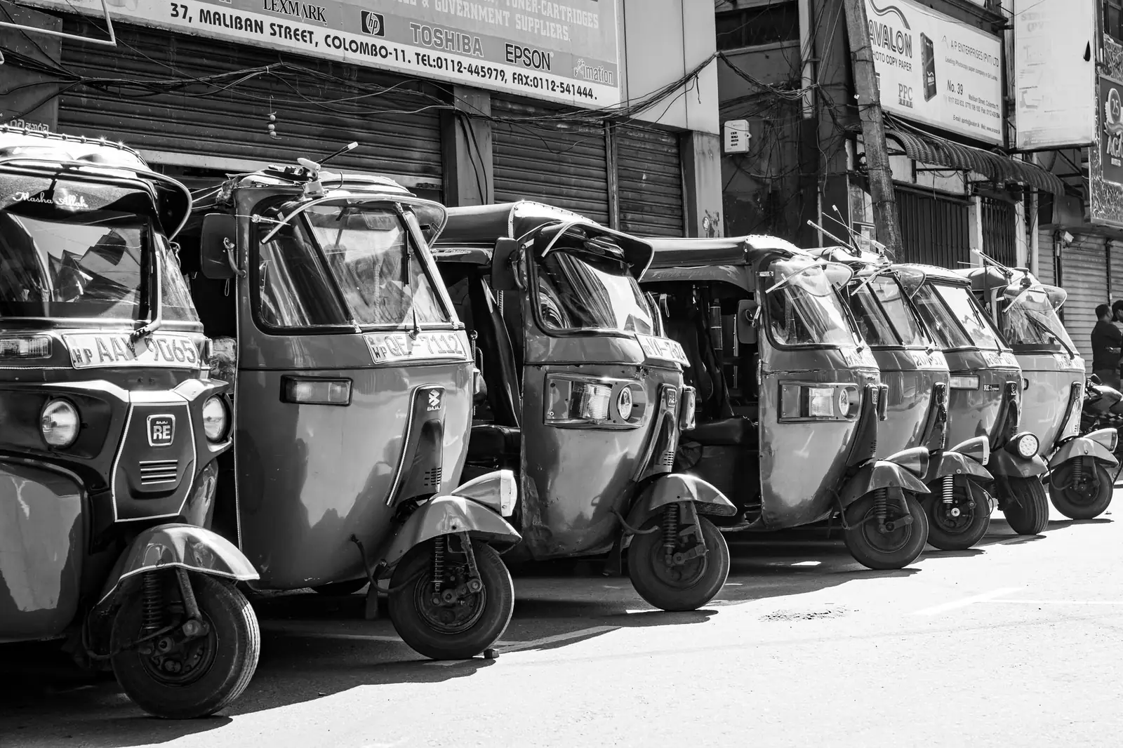 a three-wheeler tuk tuk waiting in slow Colombo traffic